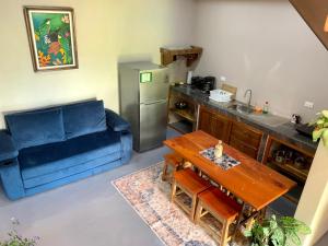 a living room with a blue couch and a table at Verde Amanecer in Bijagua