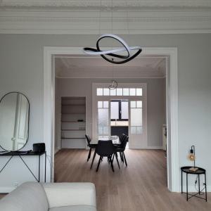 瑟蘭的住宿－Appartement Maison de Maître，客厅配有桌子和吊灯