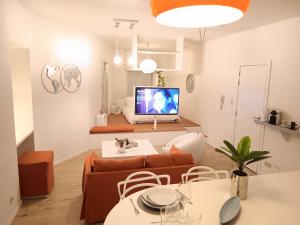 un soggiorno con divano e TV di The Luxury White Suite a Charleroi