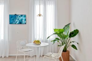 een witte eetkamer met een tafel en een plant bij La Vista di Marina by The First in Riomaggiore