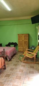 Cet appartement comprend une chambre dotée de murs verts et d'un lit. dans l'établissement Casa teocalli, à Teotitlán del Valle