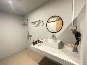 a white bathroom with a sink and a mirror at Arabica Lodge (อาราบิก้า ลอดจ์) in Ban Huai Khai