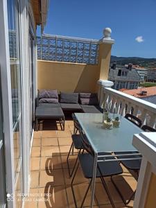 balcón con mesa, sillas y sofá en Casa da Costa - Piso con galería y terraza con vistas al mar en Cedeira