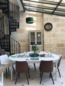 une salle à manger avec une table et des chaises blanches dans l'établissement Aquitain Home Gare Saint Jean, à Bordeaux