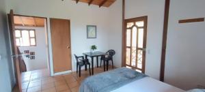 a bedroom with a bed and a table with chairs at Hostal Alma Glamping in Santa Elena