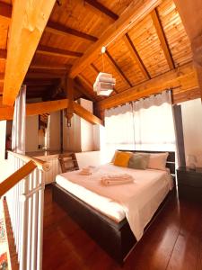 Loft Dei Lupi 260m dal Duomo FreeParking في كريمونا: غرفة نوم بسرير كبير في غرفة بسقوف خشبية