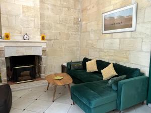 - un salon avec un canapé vert et une cheminée dans l'établissement Aquitain Home Gare Saint Jean, à Bordeaux