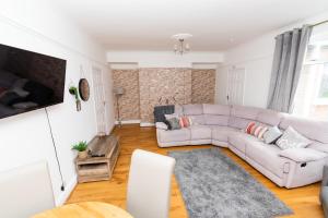 uma sala de estar com um sofá e uma televisão em Malvern - Beautiful 2 bed upper flat Ideal for Contractors Free Parking em South Shields