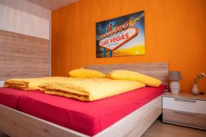 Cama en habitación con pared de color naranja en Art City Studio Kassel 2, en Kassel