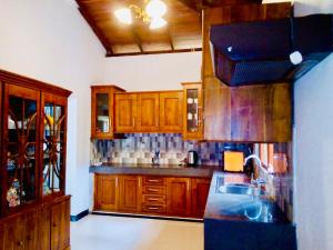 eine Küche mit Holzschränken und einem Waschbecken in der Unterkunft tashivilla in Maggona West