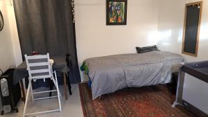 1 dormitorio con cama, escalera y silla en Studio maxi 3 pers, acces H24, proche gare pour Paris en Sainte-Geneviève-des-Bois
