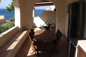 a dining room with a table and chairs and the ocean at Hiera in Acquacalda