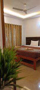 a bedroom with a bed with a table and a curtain at Oasis Beach Resort in Agonda