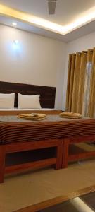 een slaapkamer met een groot bed met een houten frame bij Oasis Beach Resort in Agonda