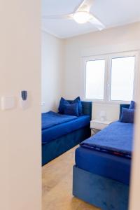 Zimmer mit 2 blauen Betten und einem Sofa in der Unterkunft Zafiro Apartment Cabo Roig in Orihuela