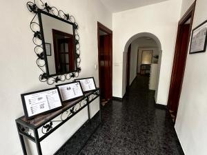 un pasillo con un espejo en la pared y una mesa en Villa Remedios, en Torremolinos