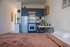 una cucina con armadi blu, tavolo e frigorifero di Holiday in Mareverde ad Adeje