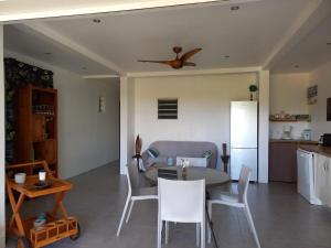 a kitchen and living room with a table and chairs at Le Tropical appartement 1 ou 2 chambres in Les Anses-dʼArlets