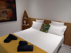 - une chambre avec un grand lit blanc et des oreillers blancs dans l'établissement Le Tropical appartement 1 ou 2 chambres, à Les Anses-d'Arlet