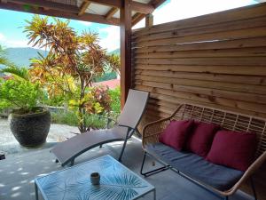 une chaise et une table sur une terrasse dans l'établissement Le Tropical appartement 1 ou 2 chambres, à Les Anses-d'Arlet