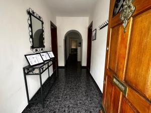 a hallway with a mirror on the wall and a table at Villa Remedios in Torremolinos