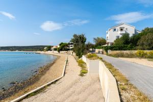 a road next to a beach with a house at Apartments Villa Tereza in Novalja