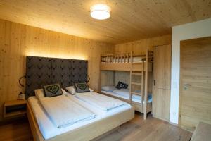 Aurach am Hongar的住宿－Holzhaus "Zum Schwarz'n"，一间卧室配有两张床和一张双层床。