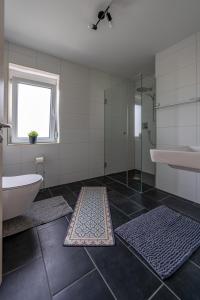 ein Bad mit einer Badewanne, einer Dusche und einem Waschbecken in der Unterkunft Apartment im Dachgeschoss in Plankstadt
