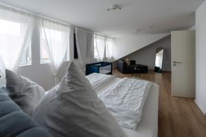 a bedroom with a white bed and a living room at Apartment im Dachgeschoss in Plankstadt