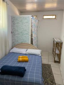 a room with a bed with a yellow pillow on it at Itajai Quartos e Suites in Itajaí