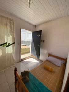 1 dormitorio con 1 cama en una habitación con ventana en Itajai Quartos e Suites en Itajaí
