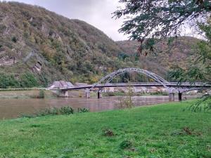 a bridge over a river next to a mountain at Gîte La Grange in Chooz