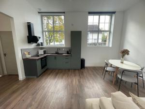 een keuken en een woonkamer met een tafel en stoelen bij Appartement avec terrasse in Dole