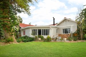 a white house with a lawn in front of it at Ukholo Lodge in Citrusdal