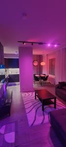a living room with purple lighting and a table at Moderni kaksio Kuopion keskustassa in Kuopio +5 photos