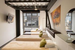4 camas en fila en una habitación en Hotel Wess, en Bogotá
