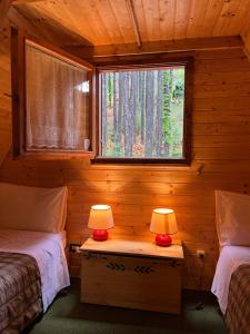 a bedroom with two beds and two lamps on a table at Chalet Natura Sport&Relax in Cavaliere
