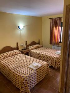 a hotel room with two beds and a window at CASA NICOLAS in Molinicos