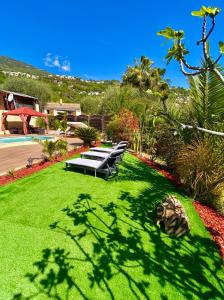 un parque con bancos y césped verde en Canarias Bungalow, en Saint-Jeannet