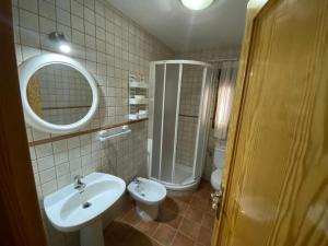 ein Badezimmer mit einem Waschbecken, einem WC und einem Spiegel in der Unterkunft CASA NICOLAS in Molinicos