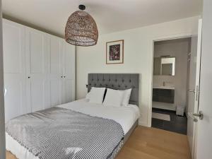 a bedroom with a white bed and a bathroom at Residence Central Park in Ostend