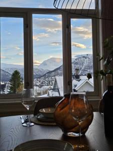 een tafel met twee wijnglazen op een tafel voor een raam bij Amazing Tromsø city apartment with free parking and lovely city views! in Tromsø