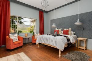 a bedroom with a bed and two chairs and a window at Ukholo Lodge in Citrusdal +7 photos