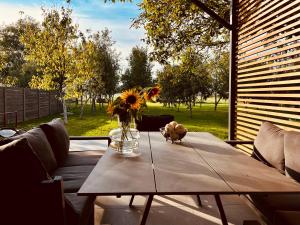 a table with a vase of flowers on top of it at House DIKA- sauna & jacuzzi in Otočac