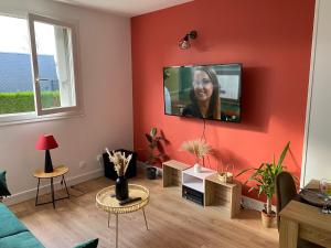 a living room with a tv on a red wall at Cosy home à 20min de paris et orly, Parking gratuit in Antony