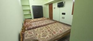 an empty bedroom with two beds in a room at Vikistays in Chennai
