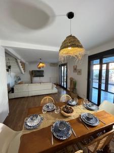Un comedor y una sala de estar con mesa y sillas. en VILLA NATURA 3 chambres 80m2 jacuzzy, en Canet-en-Roussillon