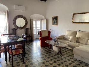 ein Wohnzimmer mit Sofa und Tisch in der Unterkunft Gran casa señorial de 300m en centro histórico in El Puerto de Santa María