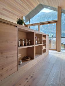 a room with wooden cabinets and a large window at Tabia' Stelo Fiorito in Santo Stefano di Cadore