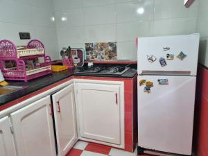 a kitchen with a white refrigerator and a stove at Lovely house with garden in Martil